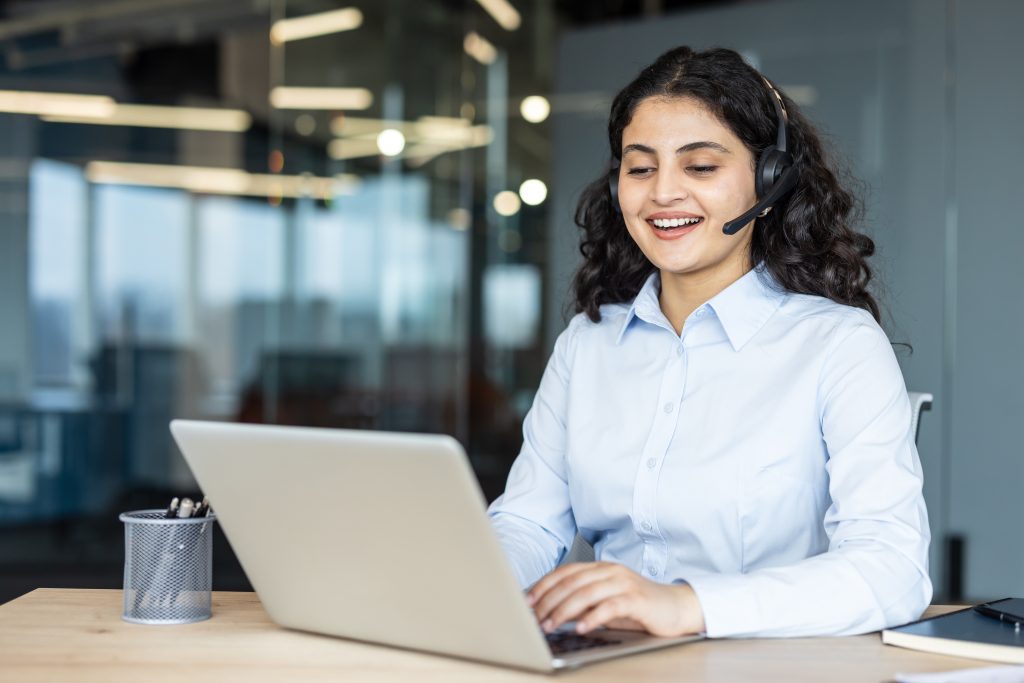 Young woman providing customer support wearing headset in office